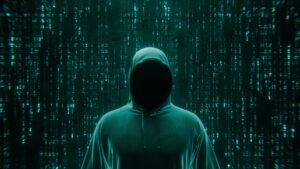 Figura encapuchada sin rostro sobre un fondo de código verde, que ilustra el ataque a una tienda PrestaShop