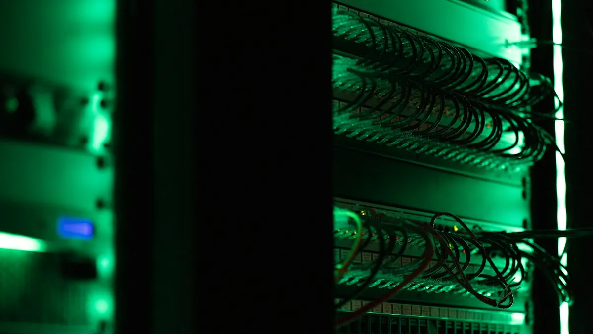 Armario de servidores con cableado iluminado en verde en una sala oscura